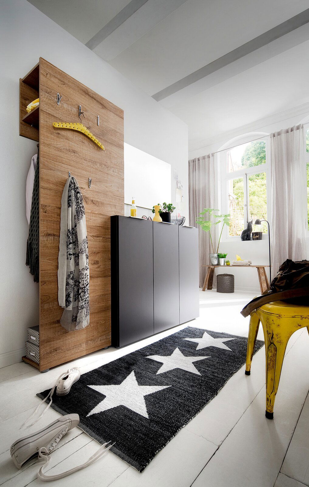 Moderner Flur mit Garderobenkombination in Holzoptik und schwarzem Schuhschrank, seitliche Perspektive