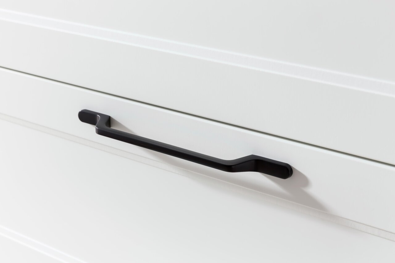 Nahaufnahme eines schwarzen Griffs an einer weißen Schublade, seitliche Perspektive