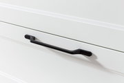 Nahaufnahme eines schwarzen Griffs an einer weißen Schublade, seitliche Perspektive