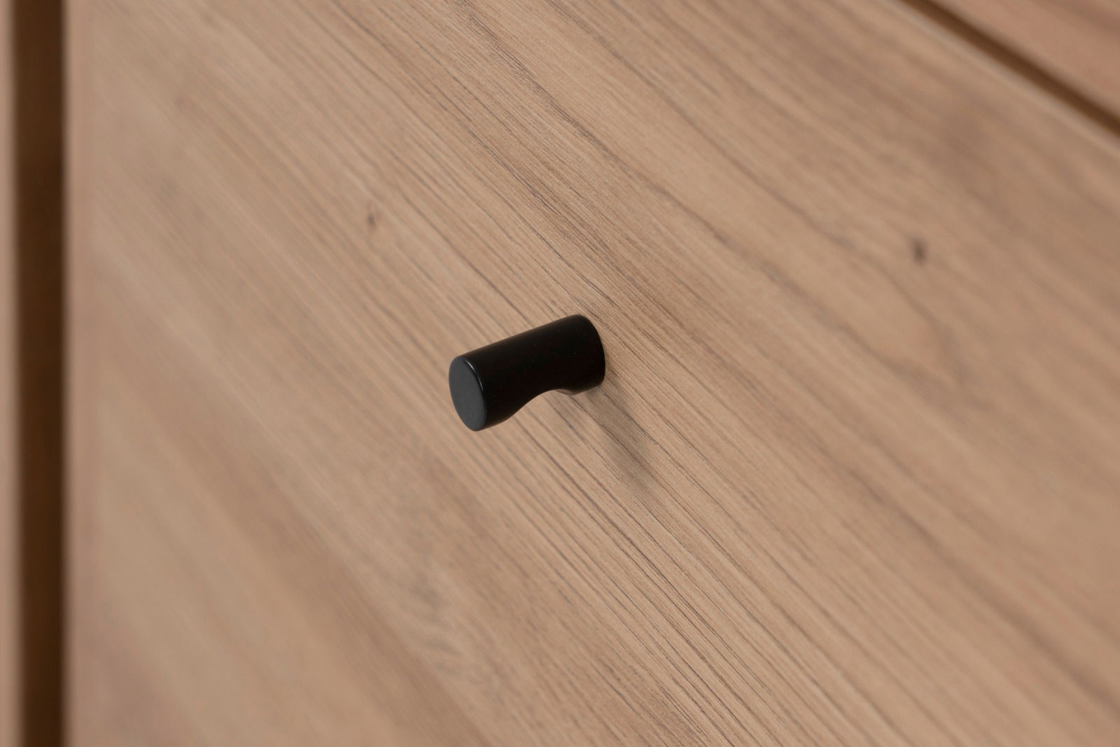 Nahaufnahme eines Holz-Sideboards mit schwarzem Griff, seitliche Perspektive