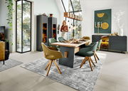 Esszimmer mit modernem Esstisch und Sesseln in einem hellen Raum mit großen Fenstern, Blick von der Seite