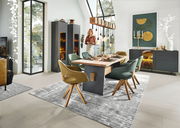 Esszimmer mit modernem Esstisch und Sesseln in einem hellen Raum mit großen Fenstern, Blick von der Seite