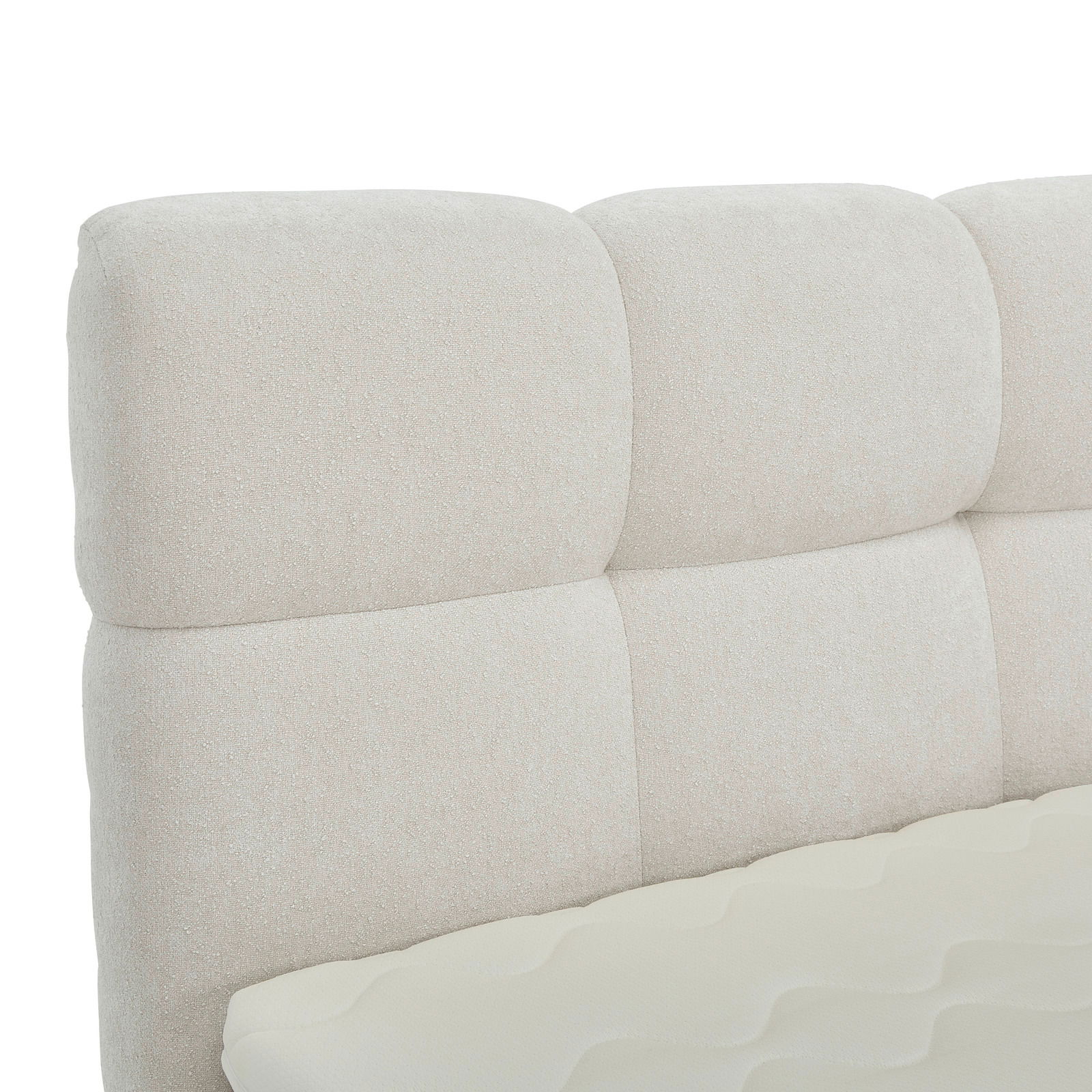 Nahaufnahme eines gepolsterten, cremefarbenen Boxbett-Kopfteil mit weicher Textur, seitliche Perspektive