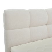 Nahaufnahme eines gepolsterten, cremefarbenen Boxbett-Kopfteil mit weicher Textur, seitliche Perspektive