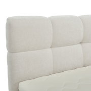 Nahaufnahme eines gepolsterten, cremefarbenen Boxbett-Kopfteil mit weicher Textur, seitliche Perspektive