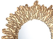 Nahaufnahme eines runden Spiegels mit einem goldfarbenen, strukturierten Rahmen in wellenförmigem Design, von oben betrachtet.