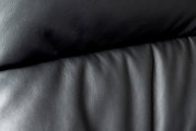 Close-up van de zwarte lederen bekleding van een directiestoel, gezien vanaf de voorkant.