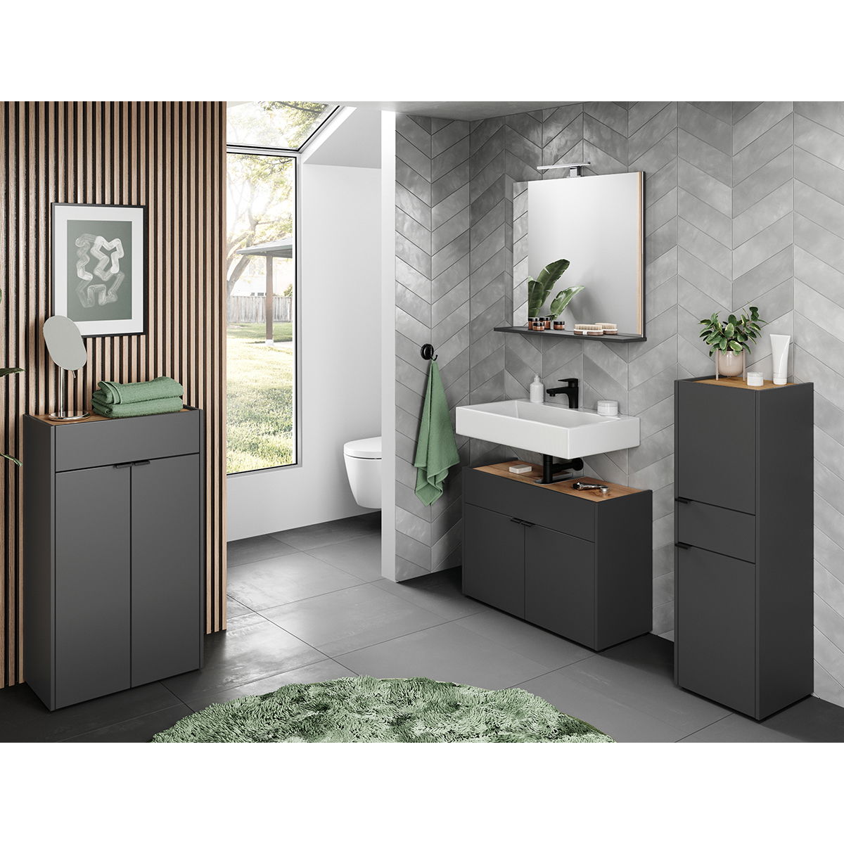 MID.YOU Kommode FORANO Moderne Badezimmerkommode in dunklem Grau mit Holzoberfläche, frontal abgebildet in einem stilvollen Badezimmer mit grauen Fliesen und grünen Akzenten.