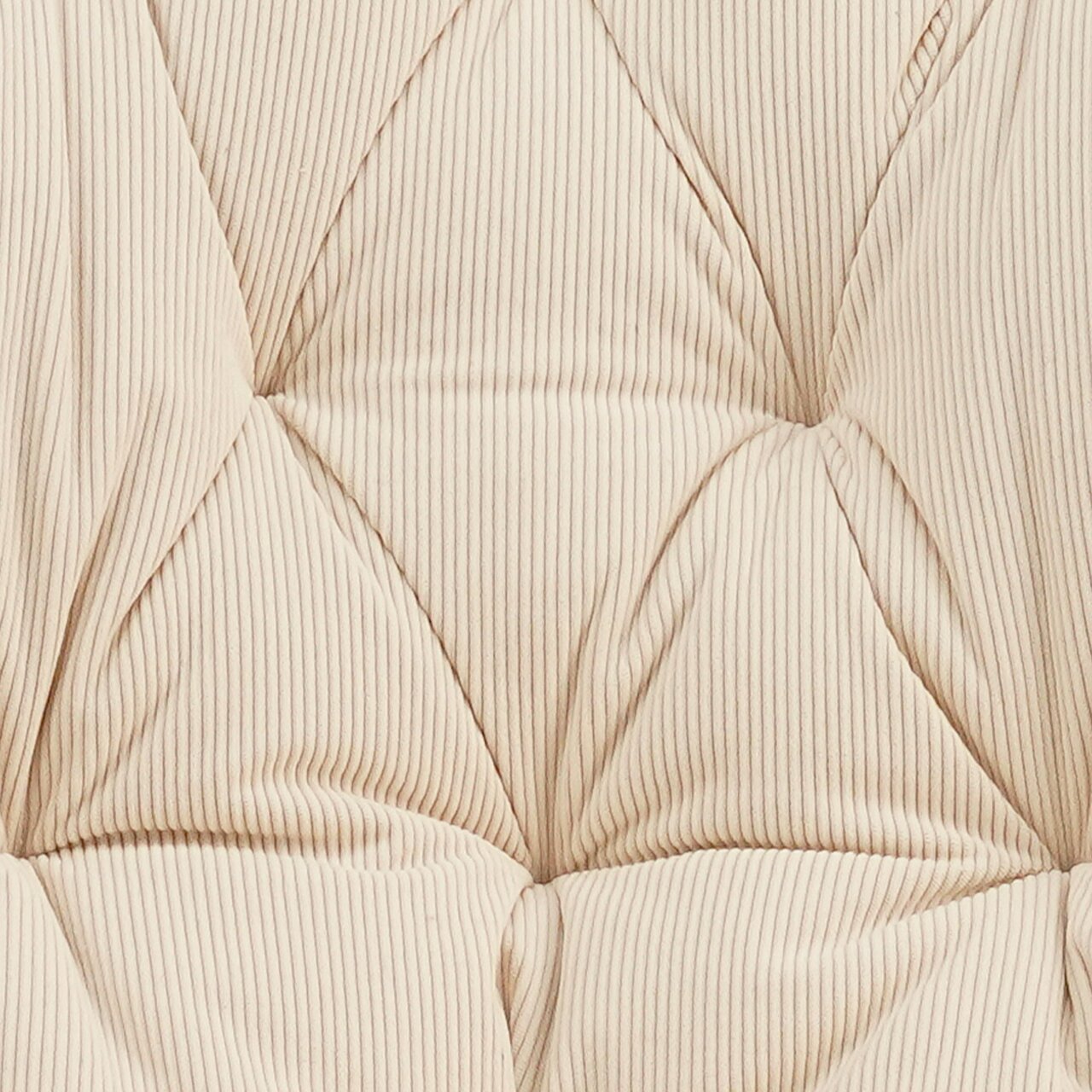 Nahaufnahme eines gesteppten, cremefarbenen Stoffes mit feinen Streifen, perspektivisch von oben betrachtet.