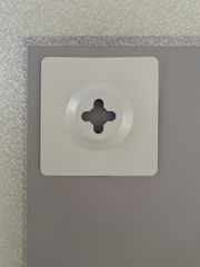 Nahaufnahme der Rückseite eines Spiegels mit einer Wandhalterung, silberner Rahmen sichtbar.