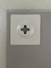 Nahaufnahme der Rückseite eines Spiegels mit einer Wandhalterung, silberner Rahmen sichtbar.