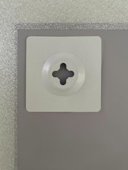 Nahaufnahme der Rückseite eines Spiegels mit einer Wandhalterung, silberner Rahmen sichtbar.