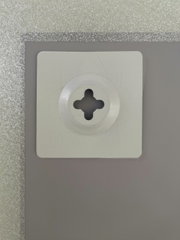 Nahaufnahme der Rückseite eines Spiegels mit einer Wandhalterung, silberner Rahmen sichtbar.