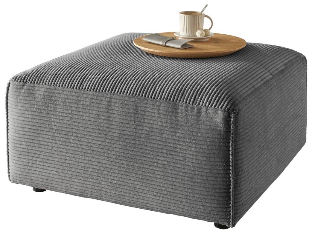 Grauer Hocker mit gerippter Oberfläche, darauf ein Tablett mit Tasse und Löffel, seitliche Perspektive