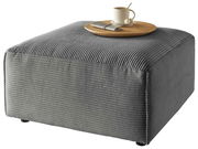 Grauer Hocker mit gerippter Oberfläche, darauf ein Tablett mit Tasse und Löffel, seitliche Perspektive