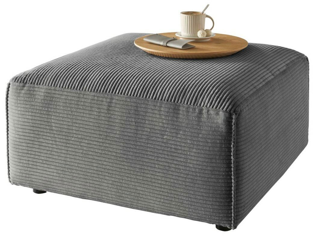 Grauer Hocker mit gerippter Oberfläche, darauf ein Tablett mit Tasse und Löffel, seitliche Perspektive