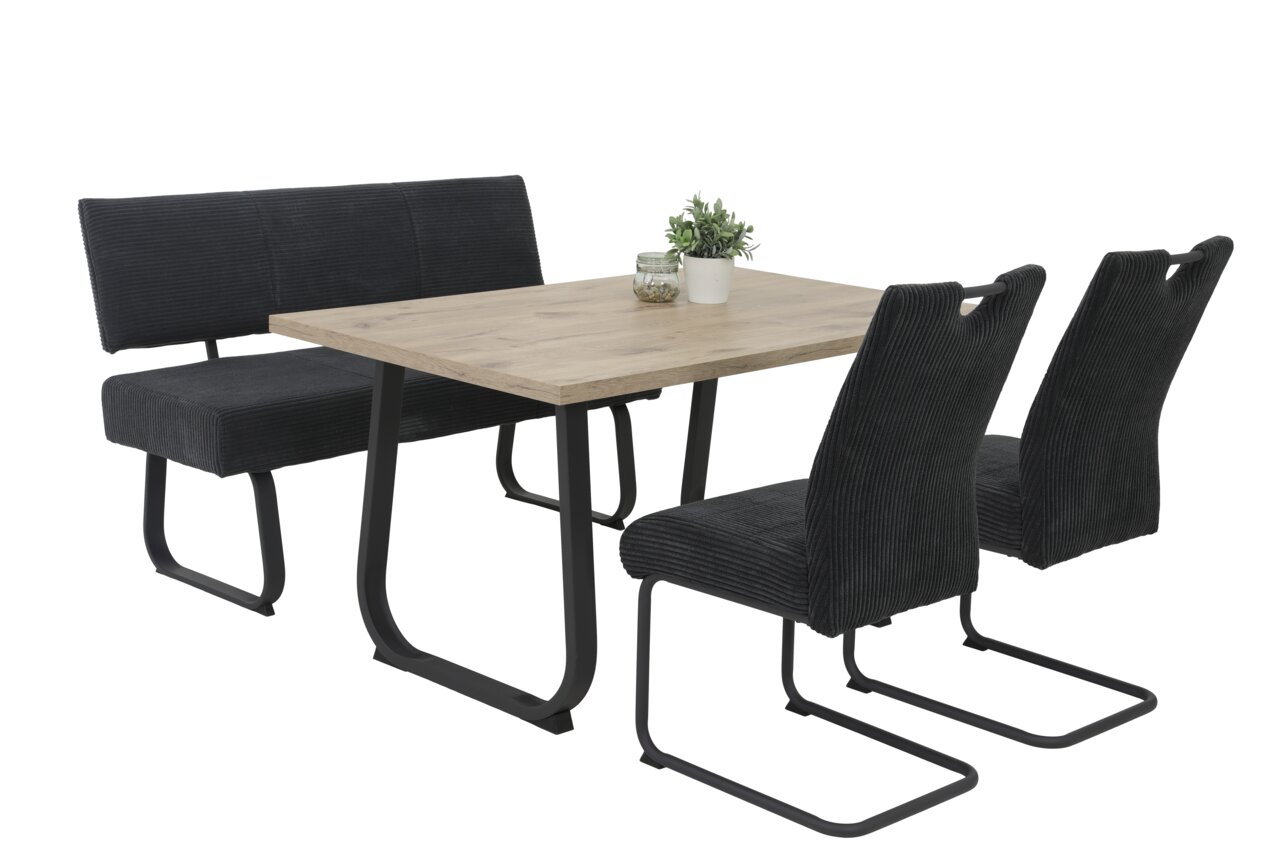 Moderne eettafel met houten blad en zwarte metalen poten, geflankeerd door twee zwarte stoelen en een zwarte bank, zijaanzicht.