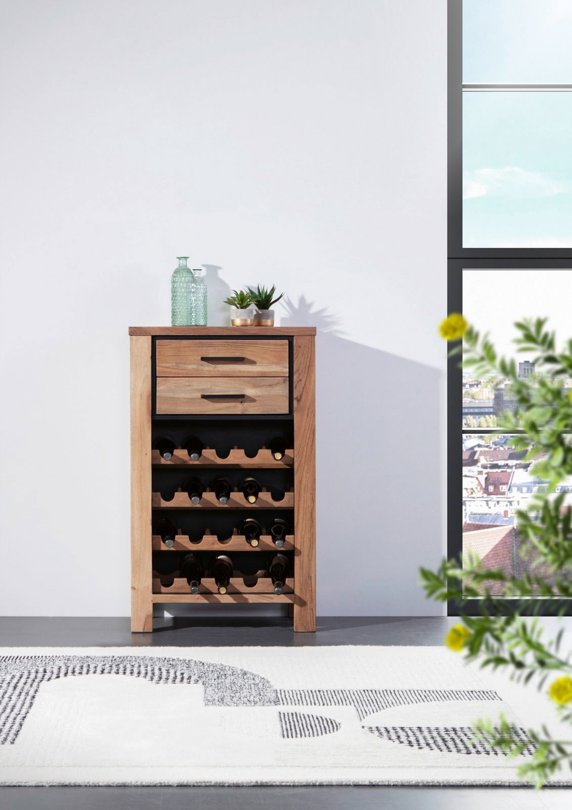 Weinregal aus Holz mit mehreren Ebenen zur Lagerung von Weinflaschen, frontal fotografiert. Auf der Oberseite stehen dekorative Glasflaschen und Pflanzen.