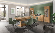 Moderner Funktions-Esstisch aus Holz in einem stilvollen Esszimmer mit grünen Stühlen und hängenden Lampen, seitliche Perspektive.