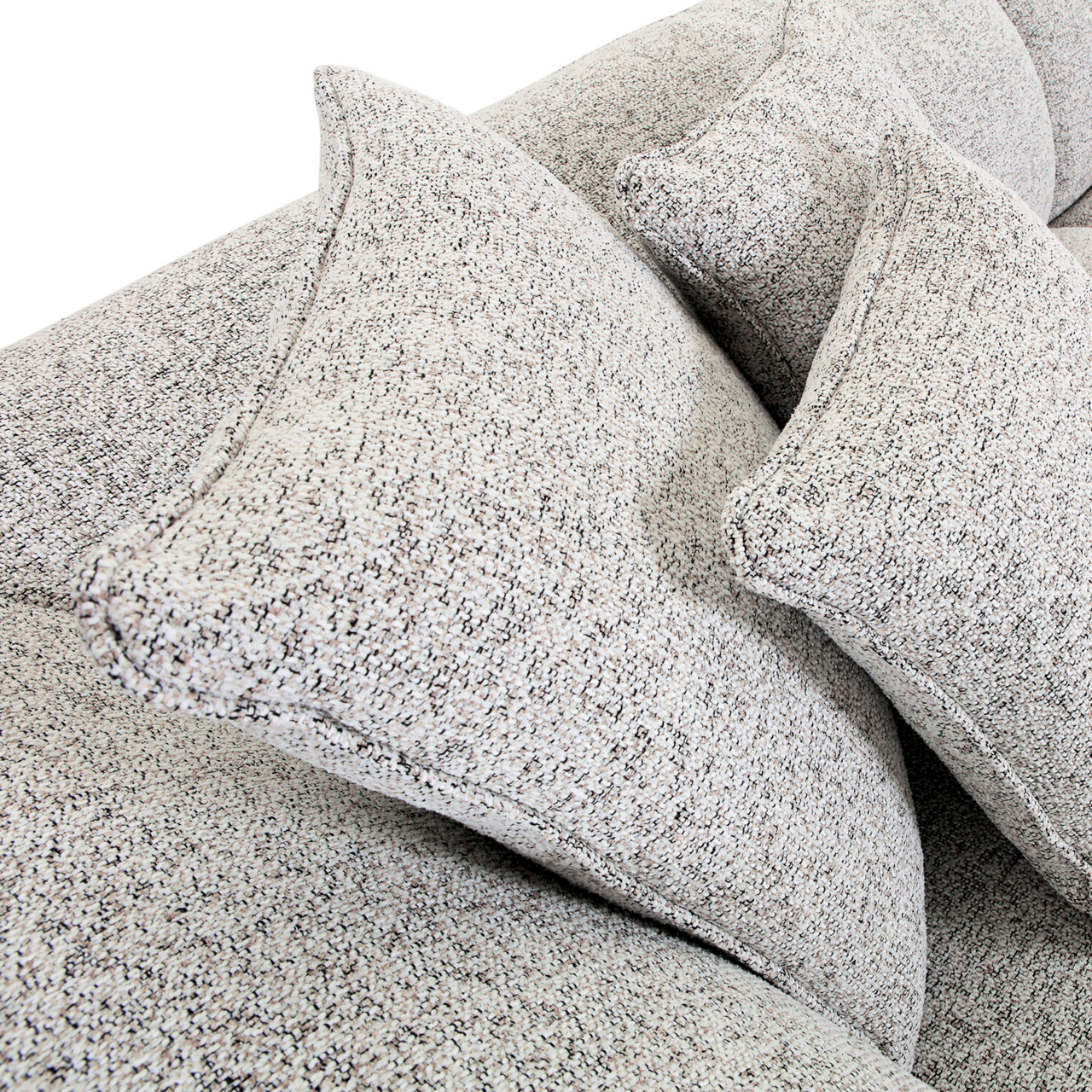 Nahaufnahme von einem Big-Sofa mit strukturiertem Stoffbezug und mehreren großen Kissen, seitliche Perspektive