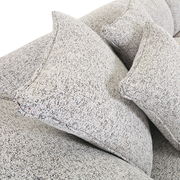 Nahaufnahme von einem Big-Sofa mit strukturiertem Stoffbezug und mehreren großen Kissen, seitliche Perspektive