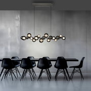 Moderne LED-Pendelleuchte über einem Esstisch, seitliche Perspektive