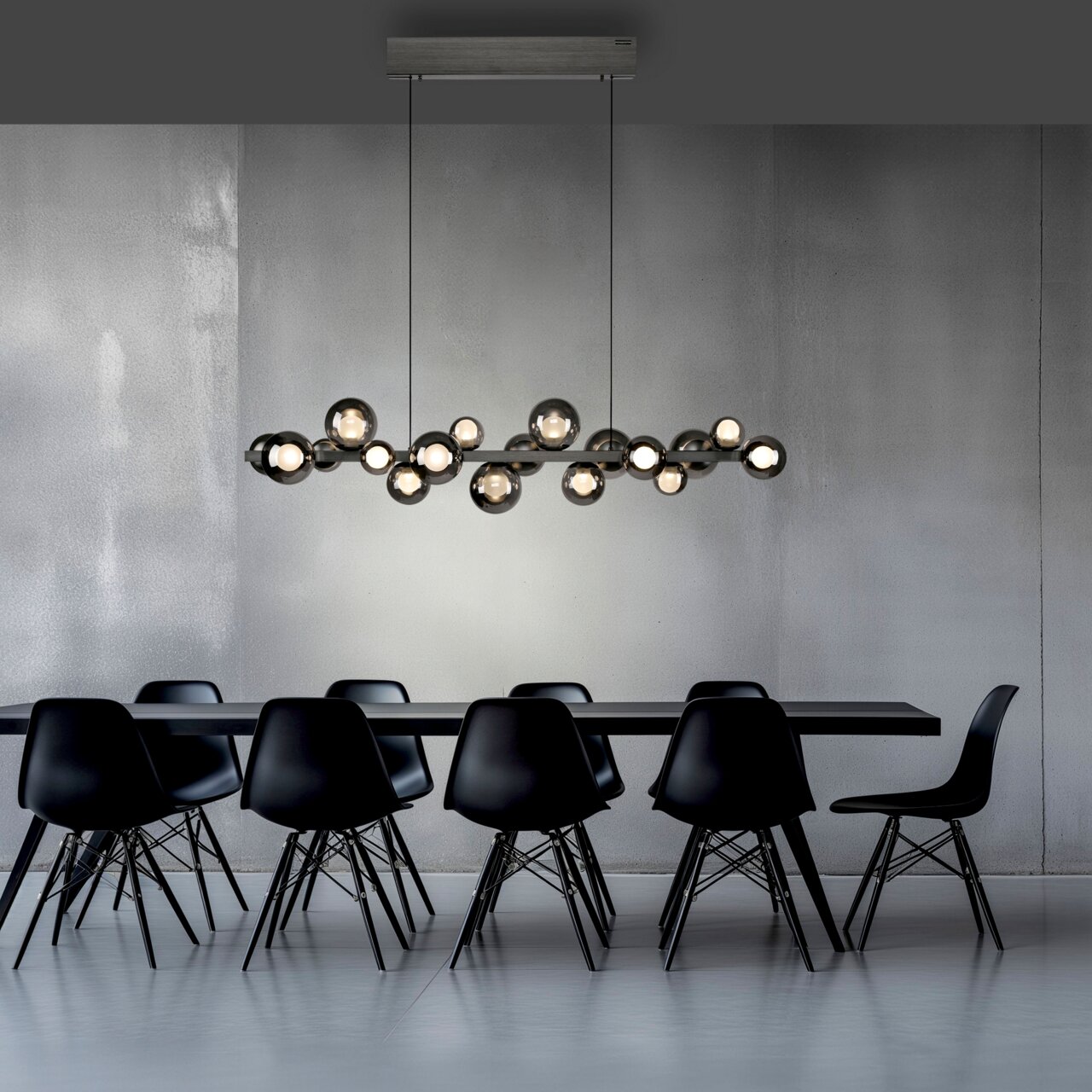 Moderne LED-Pendelleuchte über einem Esstisch, seitliche Perspektive