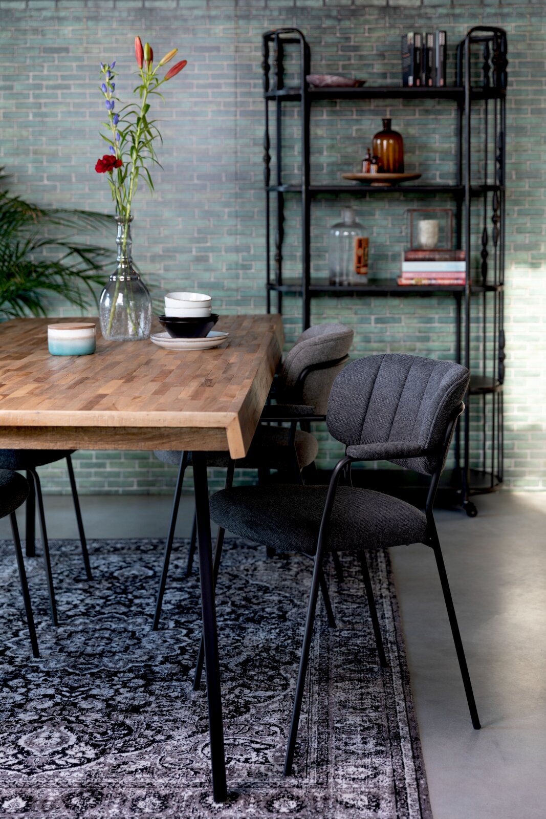 Grauer Armlehnenstuhl an einem Holztisch in einem modernen Esszimmer, seitliche Perspektive