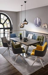 Moderner Esstisch mit Metallgestell und Holzplatte, umgeben von bunten Stühlen in einem stilvollen Esszimmer mit Blick auf ein großes Fenster.