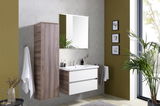 Moderner Hochschrank in Holzoptik, links im Badezimmer montiert, mit Spiegel und Waschbecken im Vordergrund.
