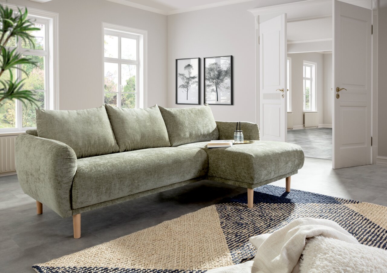 Grünes Ecksofa mit Holzfüßen in einem modernen Wohnzimmer, seitliche Perspektive