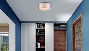 Moderne Deckenleuchte in einem stilvollen Raum mit blauen Wänden und Holzdetails, von unten betrachtet.