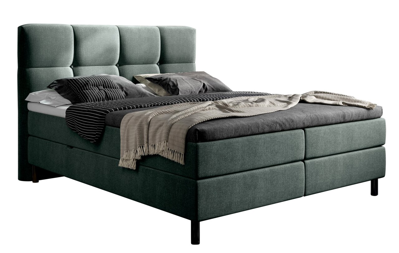 Boxbed in zijaanzicht met een gestoffeerd hoofdeinde en elegante kussens en dekens.