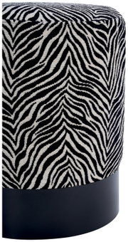 Cilindrische poef met een stoffen bekleding in zwart-wit zebraprint en een zwarte voet, gefotografeerd in een schuin vooraanzicht van bovenaf.