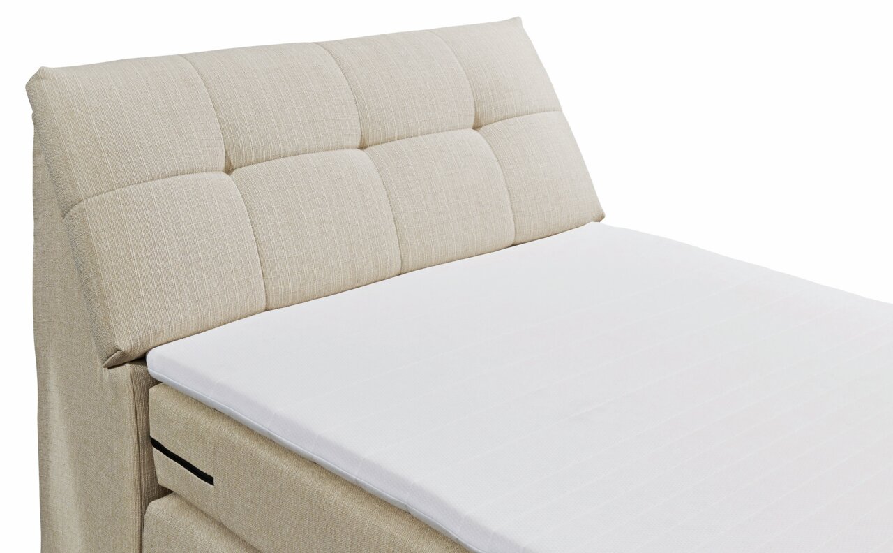 Beige Boxspringbett mit gepolstertem Kopfteil, seitliche Perspektive