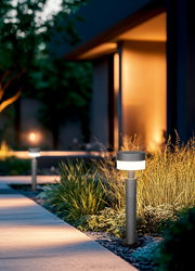 Moderne LED-Pollerleuchte in einem Garten bei Dämmerung, seitliche Perspektive