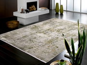 Designer Teppich in einem modernen Wohnzimmer mit Kamin, Pflanzen und dunklem Holzboden, aus einer seitlichen Perspektive fotografiert.
