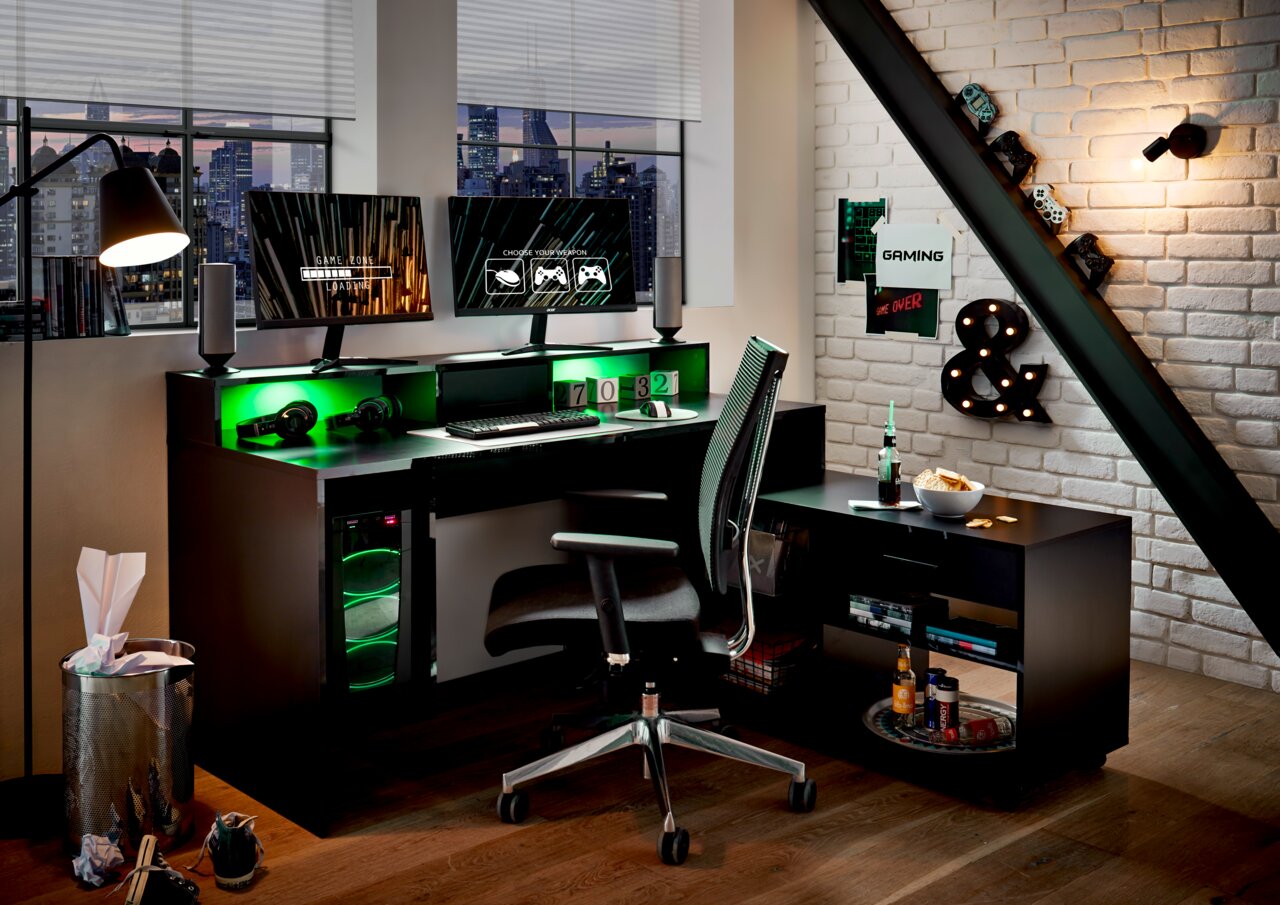 Moderner Gaming-Schreibtisch mit zwei Monitoren, LED-Beleuchtung und ergonomischem Stuhl in einem stilvollen Raum, seitliche Perspektive.