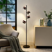 Moderne schwarze Stehleuchte mit vier kugelförmigen, rauchglasfarbenen Lampenschirmen im Wohnzimmer, seitliche Perspektive