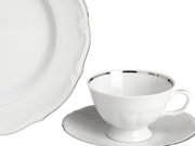 Weiße Porzellan-Teetasse mit Untertasse und silbernem Rand, daneben ein passender Teller mit gewelltem Rand, Produktansicht schräg von vorn auf weißem Hintergrund