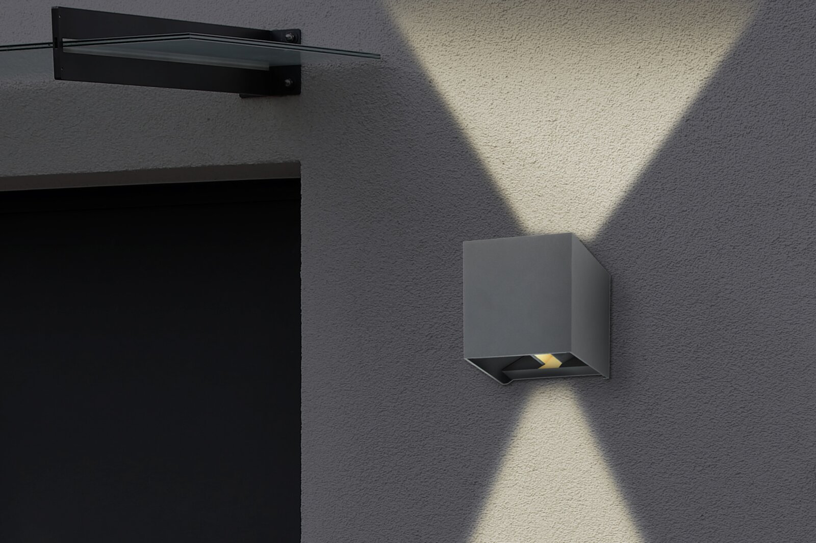 Moderne Außenleuchte in Würfelform an einer Hauswand, seitliche Perspektive