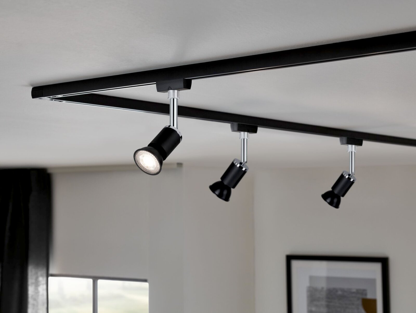 Plafondlamp met drie zwarte led-spots op een rail, zijaanzicht
