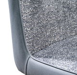 Nahaufnahme eines grauen Kufenstuhls mit strukturierter Stoffpolsterung, seitliche Perspektive