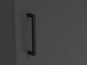 Nahaufnahme eines schwarzen Griffs an einer dunkelgrauen Kommodentür, seitliche Perspektive