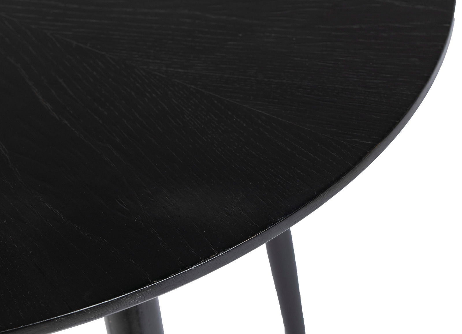 Nahaufnahme eines schwarzen runden Esstisches mit sichtbarer Holzmaserung, Perspektive von oben.