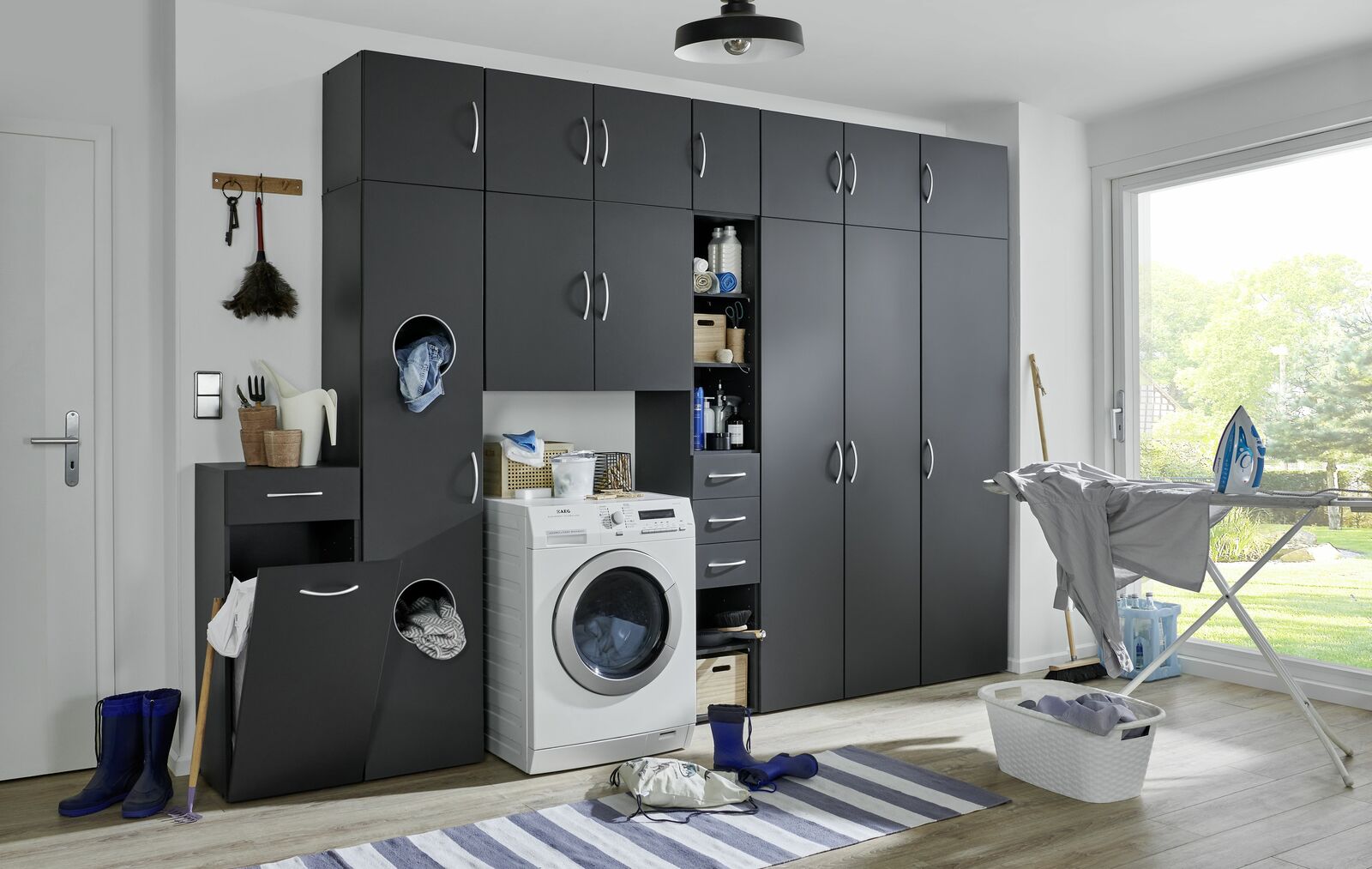 Moderner Wäscheschrank in dunklem Design mit Waschmaschine und Stauraum, seitliche Perspektive