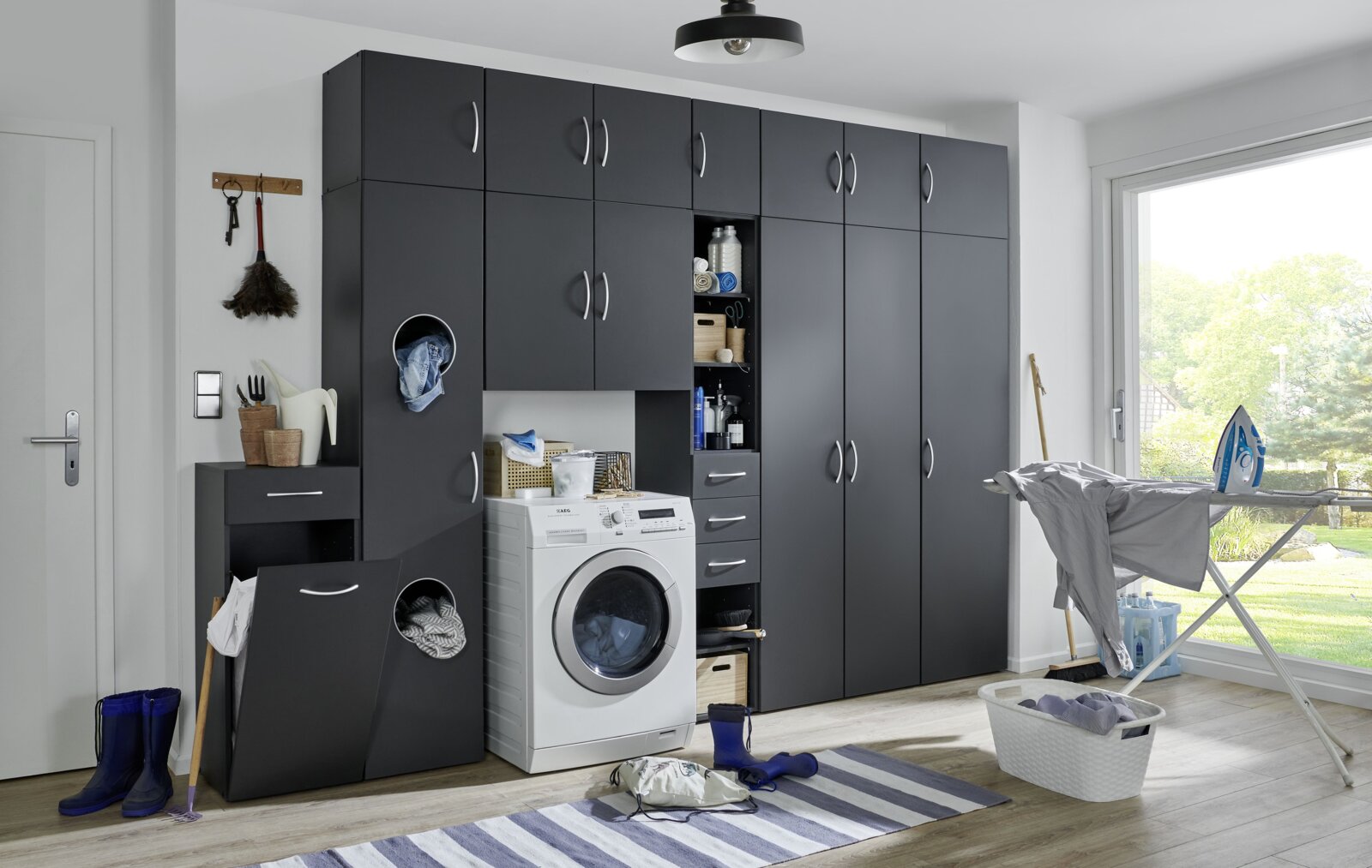 Moderne waskast in een donkere uitvoering met wasmachine en opbergruimte, zijaanzicht