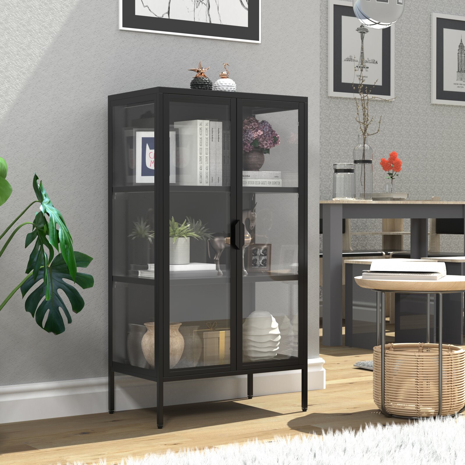 Schwarzer Vitrinenschrank mit Glasfront und Metallrahmen, dekoriert mit Büchern, Vasen und Pflanzen, in modernem Wohn-/Essbereich; Perspektive: frontale leicht schräge Ansicht von links auf Augenhöhe.