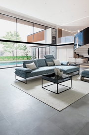 Moderne Longchairkombination in einem eleganten Wohnzimmer mit großen Fenstern, seitliche Perspektive