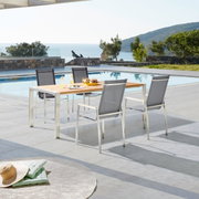Moderne tuinstoel Amatio CHUR op een terras met uitzicht op een zwembad en de zee, zijaanzicht.